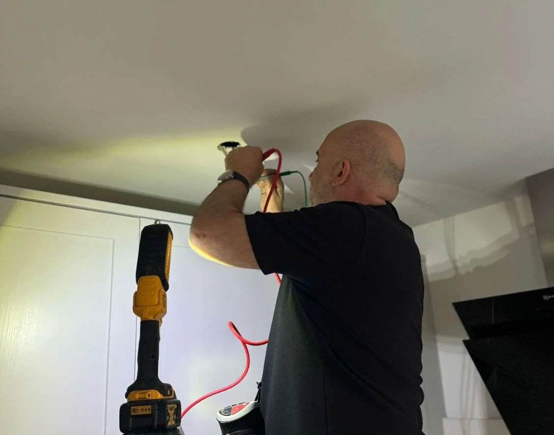 Electrician from Fahri Electricians carrying out ceiling wiring safety inspection in a London home