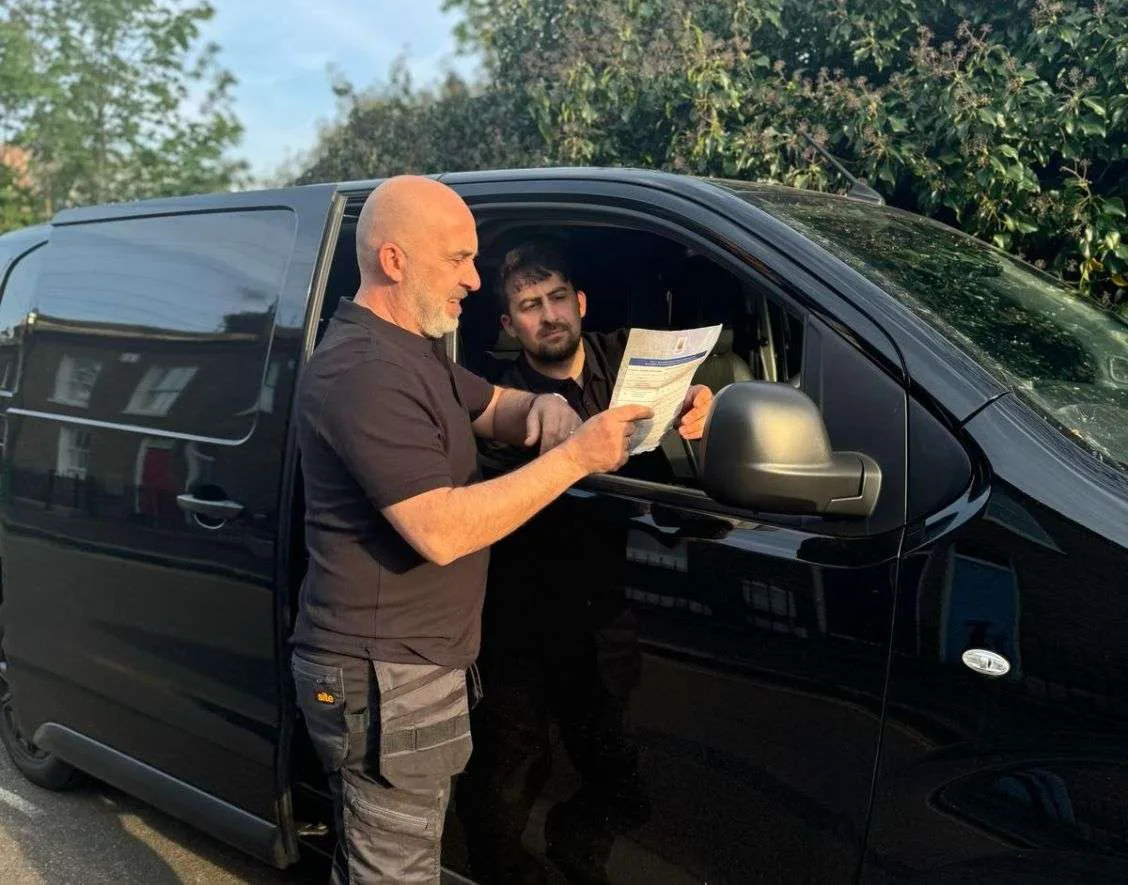 Team from Fahri Electricians reviewing property maintenance schedule beside their van in London